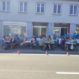 Bild enthält, City, Urban, People, Person, Street, Restaurant, Neighborhood, Building, Cafeteria, Pants