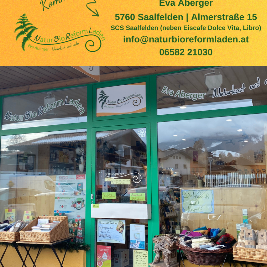 Die Eingangstür eines Ladens namens Natur Bio Reform Laden, mit einer grünen Tür und Glasfenstern, und ausgestellten Artikeln davor. Der Laden befindet sich in 5760 Saalfelden, Almstrasse 15.