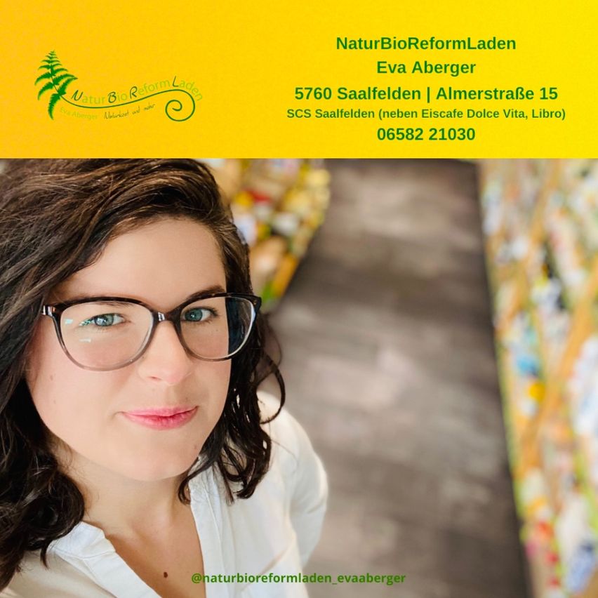 Eine Frau mit Brille steht in einem Geschäft und schaut direkt in die Kamera. Hinter ihr sind Regale mit Produkten zu sehen. Der Hintergrundtext lautet NaturBioReformLaden, Eva Aberger, mit Adresse und Telefonnummer.