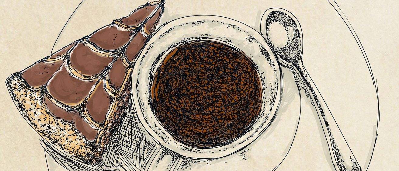Eine Tasse Kaffee mit einer Schaumkrone, neben einem Gebäck auf dem Teller. Ein Löffel liegt neben der Tasse.