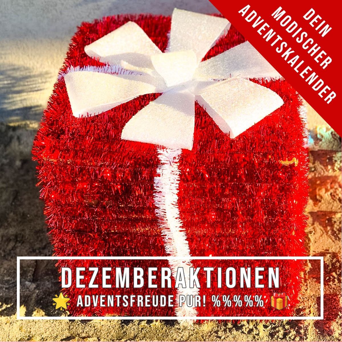 Ein rotes Geschenk mit einer weißen Schleife. Es hat die Worte 'Dezemberaktionen Adventsfreude Puri! % % % % %%' am Boden.