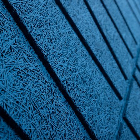 Eine Nahaufnahme einer blauen strukturierten Oberfläche mit dünnen, wellenförmigen Linien, die vertikal verlaufen. Die Textur ist faserig und erscheint gefroren.