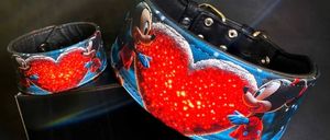 Zwei Mickey-Mouse-Halsbänder mit leuchtendem Herzdesign, eines in Blau und eines in Rot, auf schwarzem Hintergrund präsentiert.
