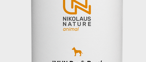 Ein weißer zylindrischer Behälter mit der Aufschrift 'IMUN Dog® Para' und einem grünen Streifen. Enthält 115g Pulver. Der Behälter stammt von 'Nikolaus Nature animal' und zeigt ein Hundelogo. Es fördert eine bessere Welt für Hunde.