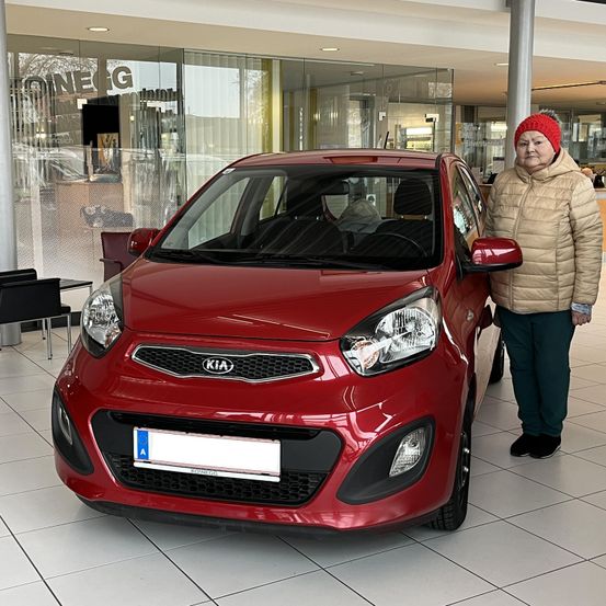 Bild enthält, Car, Vehicle, Person, Jacket, Wheel, Bumper, Chair, Car Dealership, Face, Shoe