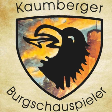 Ein Wappen zeigt eine Silhouette eines Ziegenbocks mit Hörnern vor einem Hintergrund aus orange und gelbem Himmel. Die Wörter 'Kaumberger' und 'Burgschauspieler' sind über und unter dem Wappen angebracht.