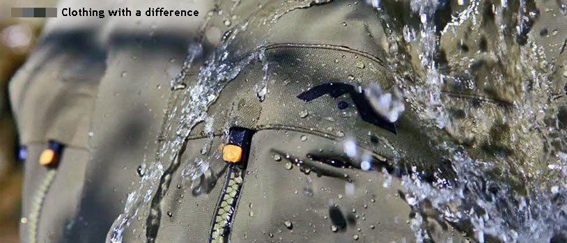 Ein Nahaufnahme eines khakifarbenen Jacken mit Reißverschluss und Wassertropfen, die darum sprühen. Die Jacke scheint wasserdicht zu sein.
