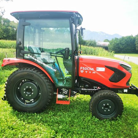 Bild enthält, Grass, Plant, Machine, Wheel, Tractor, Transportation, Vehicle, Lawn, Lawn Mower, Tool