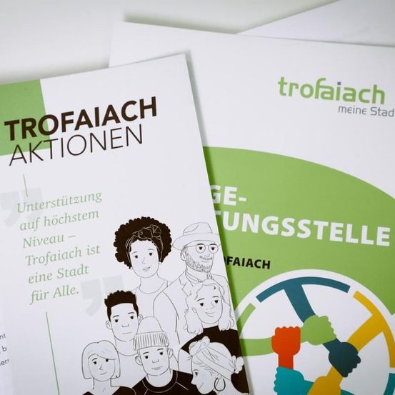 Ein Broschürentitel Trofaiach Aktionen mit einer vielfältigen Gruppe von Menschen mit dem Slogan Trofaiach ist eine Stadt für alle.