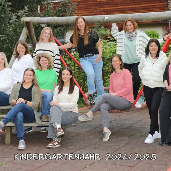 Eine Gruppe von Frauen posiert für ein Foto im Spielplatz, in lässiger Kleidung. Der Text am unteren Rand lautet 'Kindergartenjahr 2024/2025'.