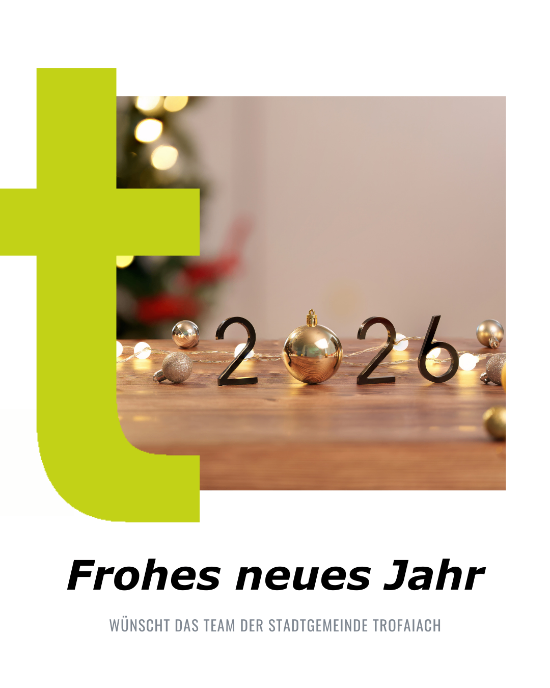 Ein grüner Buchstabe T mit der Zahl 2026 und goldenen Weihnachtskugeln auf einem Holztisch. Der Text lautet 'Frohes neues Jahr', was 'Frohes neues Jahr' auf Deutsch bedeutet.