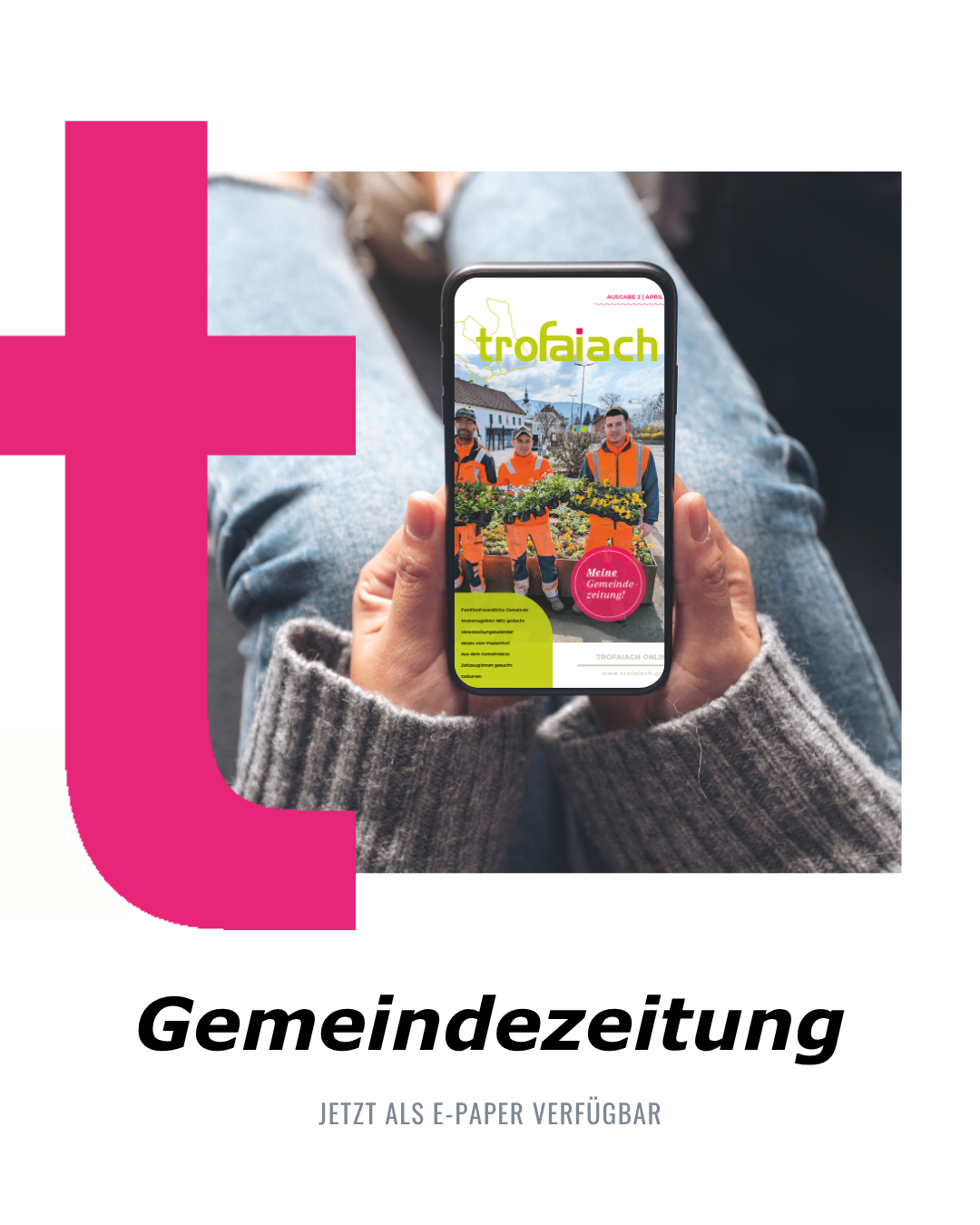 Eine Person hält ein Handy mit der Anzeige der Trofaiach Gemeindezeitung. Sie trägt einen grauen Pullover. Der Handybildschirm zeigt Personen in orangefarbenen Westen.