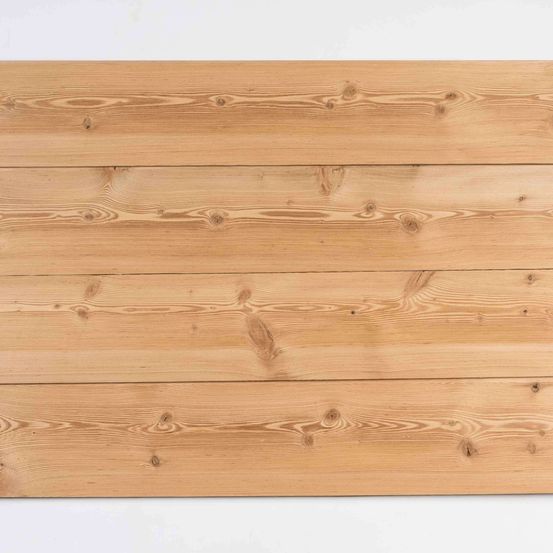 Ein Nahaufnahme eines Holzpaneels mit sichtbaren Holzmaserungen. Das Holz hat eine helle, natürliche Farbe und erscheint glatt. Es ist in mehrere horizontale Abschnitte unterteilt.