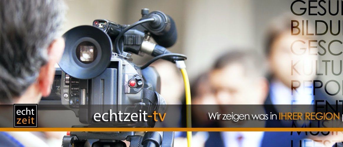 Eine Kamera mit einem Mikrofon steht im Vordergrund, mit verschwommenen Figuren in Anzügen dahinter. Der Text lautet 'Zeitzeit-tv' und 'Wir zeigen was in Ihrer Region' auf Deutsch.