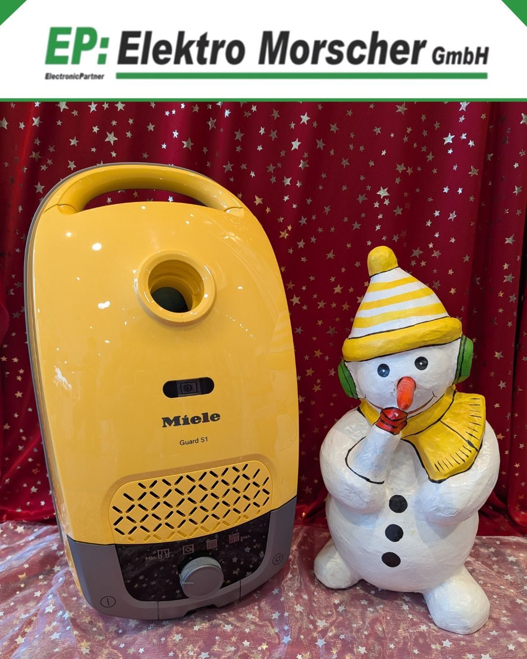 Ein gelber Miele Guard S1 Staubsauger und ein Schneemann mit gelbem Hut, Schal und Kopfhörern werden vor einem roten Hintergrund mit Sternen gezeigt.