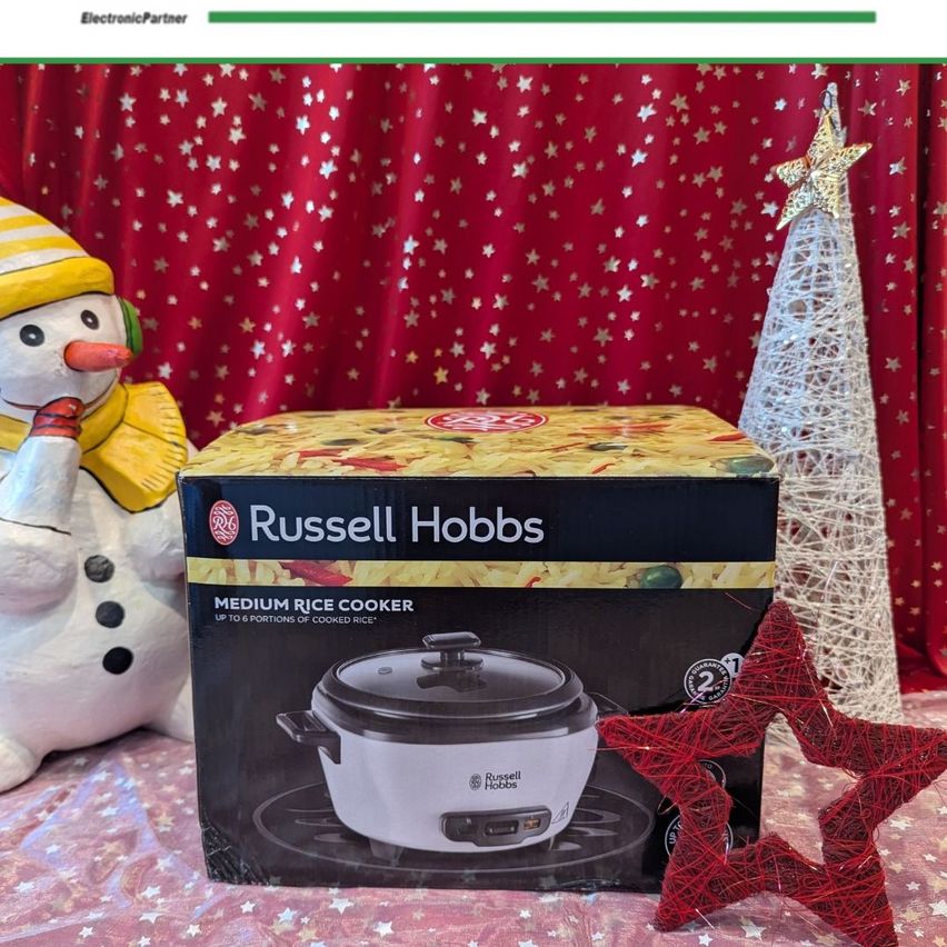 Eine Schachtel des Russell Hobbs Medium Reiskochers mit einem Schneemann und Weihnachtsbäumen im Hintergrund.