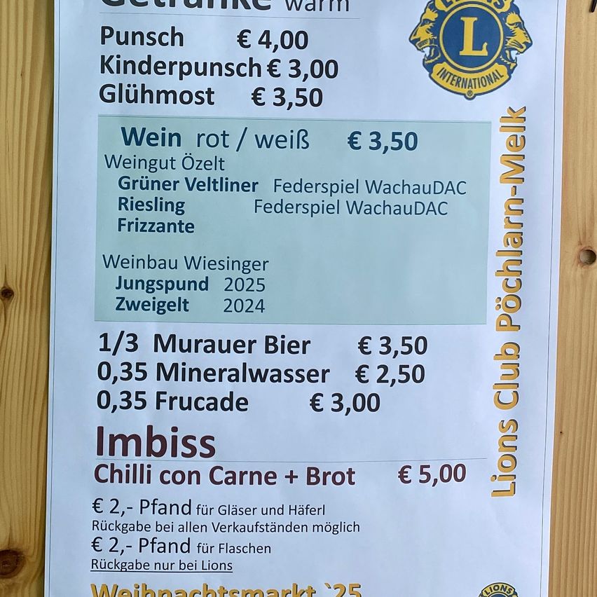 Ein Menü bietet verschiedene Getränke und Speisen an. Warme Getränke umfassen Punsch für 4 €, Kinderpunsch für 3 € und Glühwein für 3,50 €. Weinauswahlen umfassen rot/weiß für 3,50 €, bezogen von Weingut Oezel. Speiseoptionen umfassen Chili con Carne für 5 €. Rückerstattbare Kautionen gelten für Gläser und Flaschen.