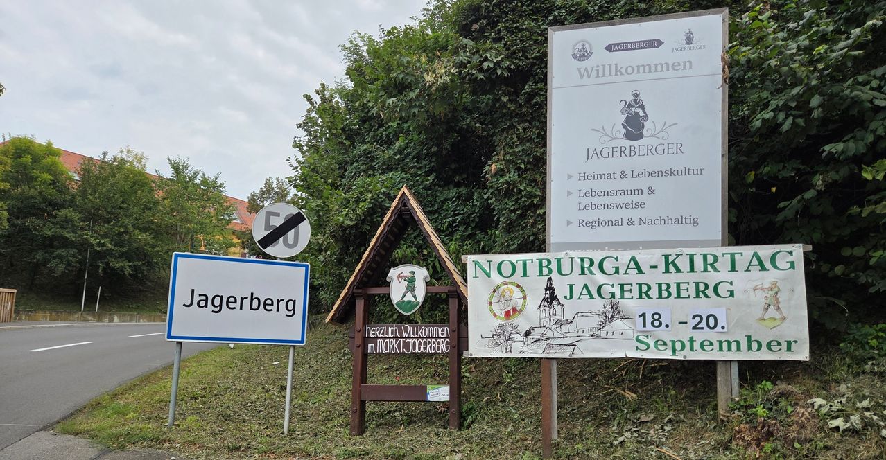 A sign reading 'Jagerberg' is placed on a grassy area with a small house-like structure and a signboard with a drawing of a church.