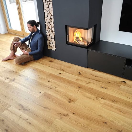 Bild enthält, Interior Design, Person, Sitting, Wood, Fireplace, Floor, Hardwood, Flooring, Adult, Man