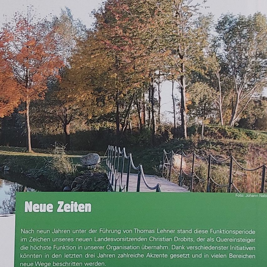 Ein Park mit Bäumen, einer Holzbrücke und einem Gewässer. Ein grünes Schild mit weißem Text steht 'Neue Zeiten'. Ein Zitat in Deutsch über die neue Periode unter der Führung von Christian Drobit.