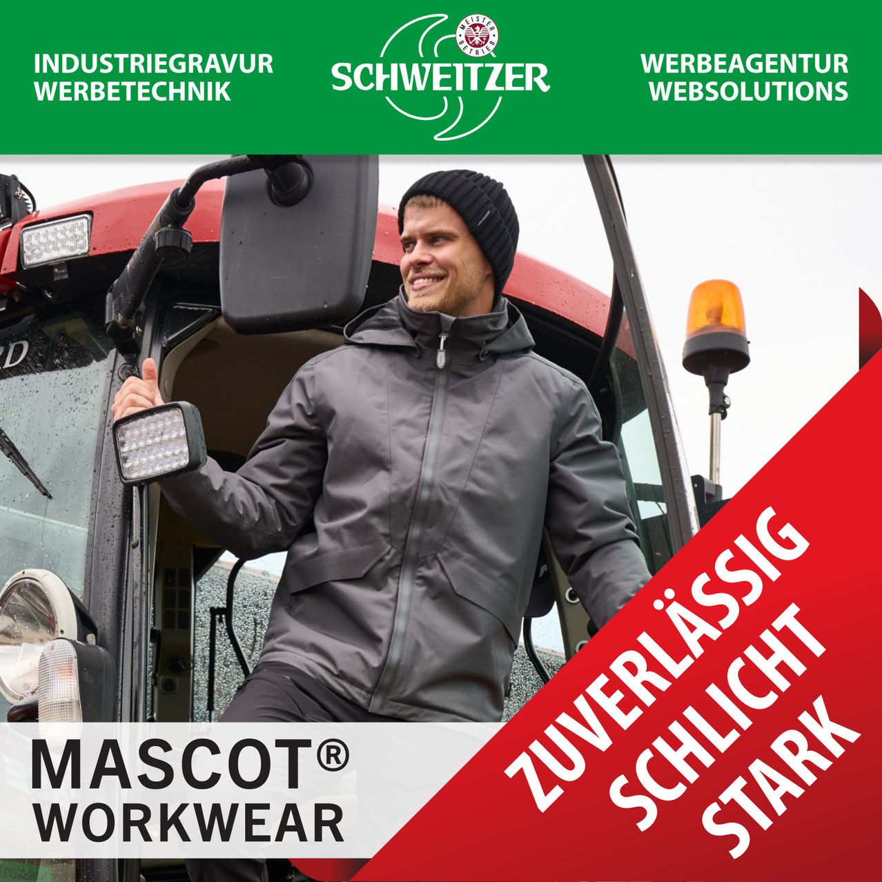 Ein lächelnder Mann in einer grauen Jacke sitzt in einem Traktor mit einem roten Banner mit weißen Schriftzügen und einem roten Dreieck an der Seite.