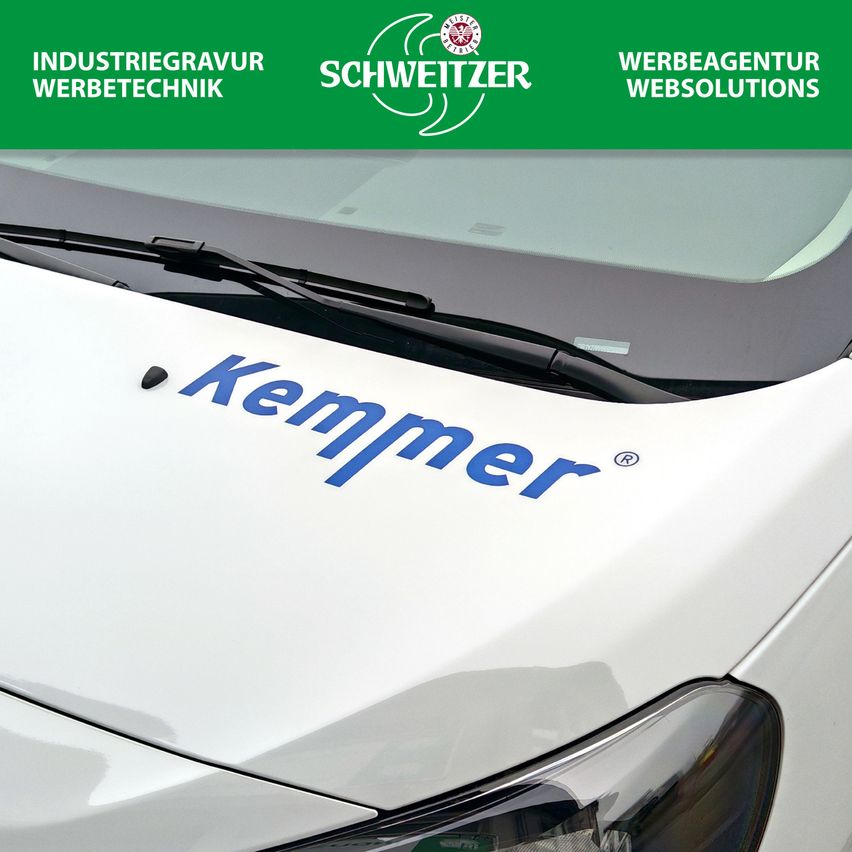 A white vehicle with a logo that reads 'Kemmer' is featured. The vehicle has a black windshield wiper. The vehicle's hood is gray. The text 'Industriegravur Werbetechnik' and 'Webagentur Websolutions' is on a green banner.