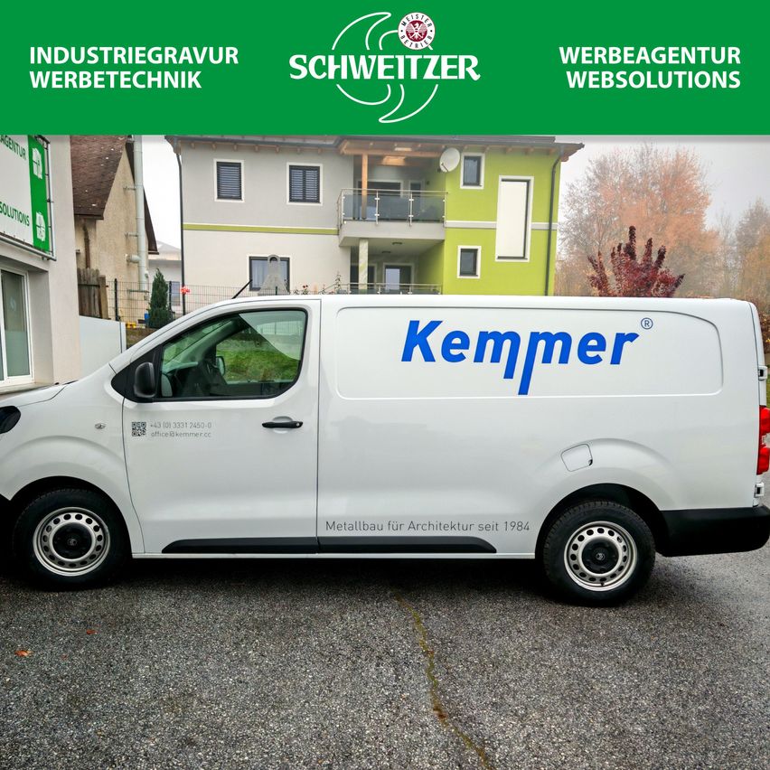 A white van with the name Kempner is parked in front of a building. The van has the logo of Kempner on the side. Behind the van is a building with a balcony and trees.