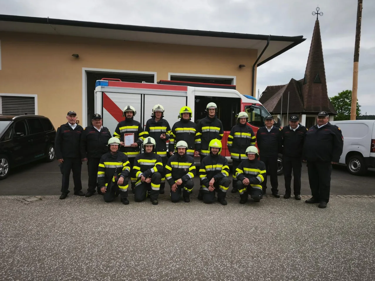 Eine Gruppe von Feuerwehrleuten posiert für ein Foto vor ihrer Feuerwache.