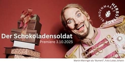 Ein lächelnder Mann in Uniform steht neben einem Stapel Geschenkboxen. Der Text lautet 'Der Schokoladensoldat Premiere 3.10.2025'. Martin Mairinger wird als 'Bumler' genannt. Das Foto ist von Lukas Johann.