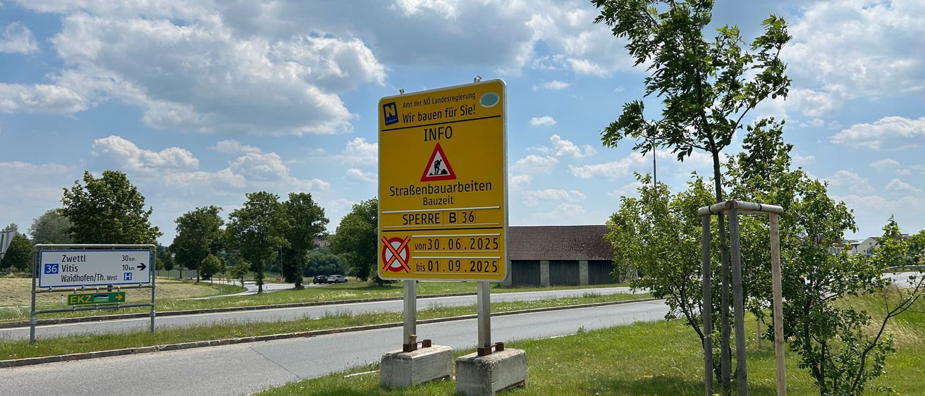 Ein gelbes Schild mit dem Wort Info darauf. Es warnt vor Straßenbauarbeiten vom 30.06.2025 bis 01.09.2025.