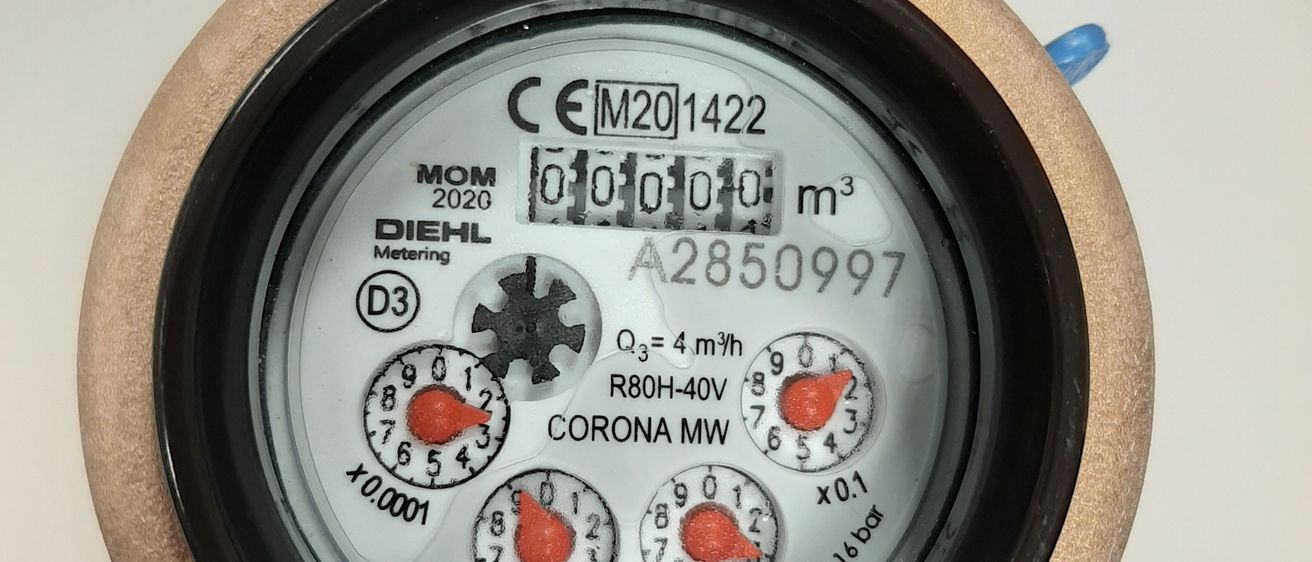 Nahaufnahme eines Wasserzählers, zeigt die Marke 'MOM DIEHL', ein CE-Zeichen und Ablesungen von 0,000 Kubikmetern, 'A2850997' und '750 16 bar'.