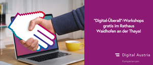 Eine Person hält ein Schild mit den Worten 'Digital-Uberall' vor einem Laptop mit einer Tasse.