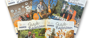 Sechs Zeitschriften auf schwarzem Hintergrund, jeweils mit dem Titel 'Stadtnachrichten'. Eine zeigt eine Frau mit einem Korb, eine andere ein Familienbild im Garten. Die anderen zeigen verschiedene Szenen, darunter ein Pool, eine Gruppe von Menschen und ein Familienfoto.