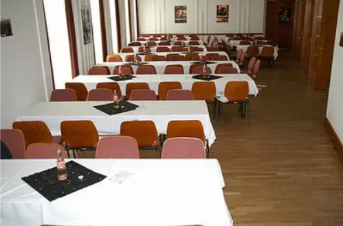 Bild enthält, People, Indoors, Classroom, School, Hall, Crowd, Audience, Lecture, Furniture, Lecture Hall