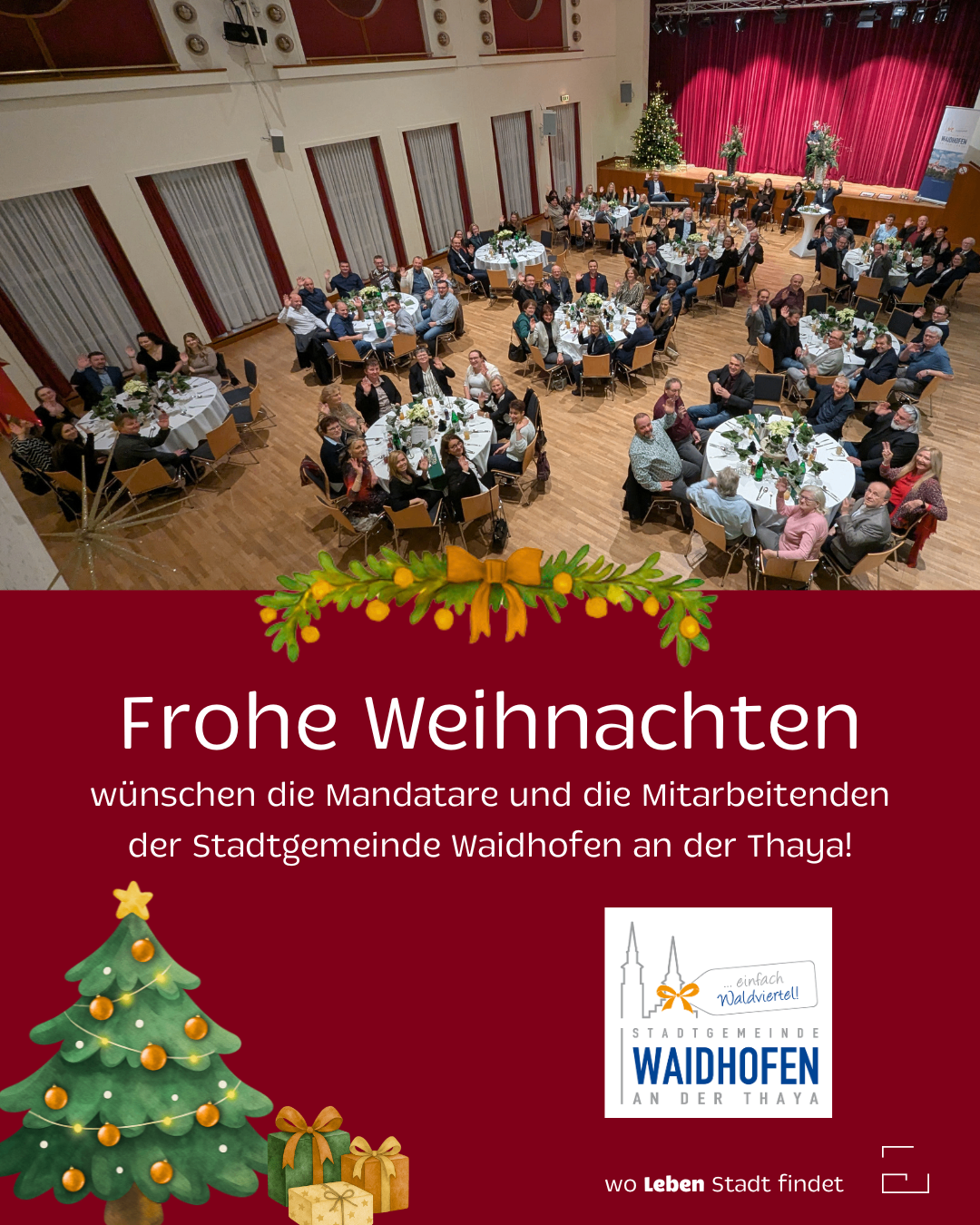 Ein Blick aus der Luft auf einen Speisesaal mit Menschen an Tischen, geschmückt mit Blumen und einem Weihnachtsbaum. Eine Weihnachtsbotschaft auf Deutsch lautet 'Frohe Weihnachten' und wünscht allen ein frohes Weihnachtsfest.