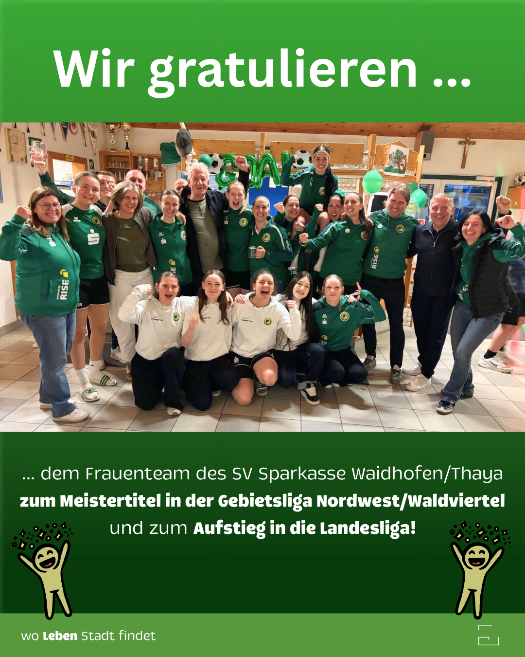Ein Gruppenfoto eines Teams in grünen und weißen Uniformen. Sie feiern mit einem Banner, das 'Wir gratulieren...' lautet. Sie sind in einem Raum mit Luftballons und Trophäen.