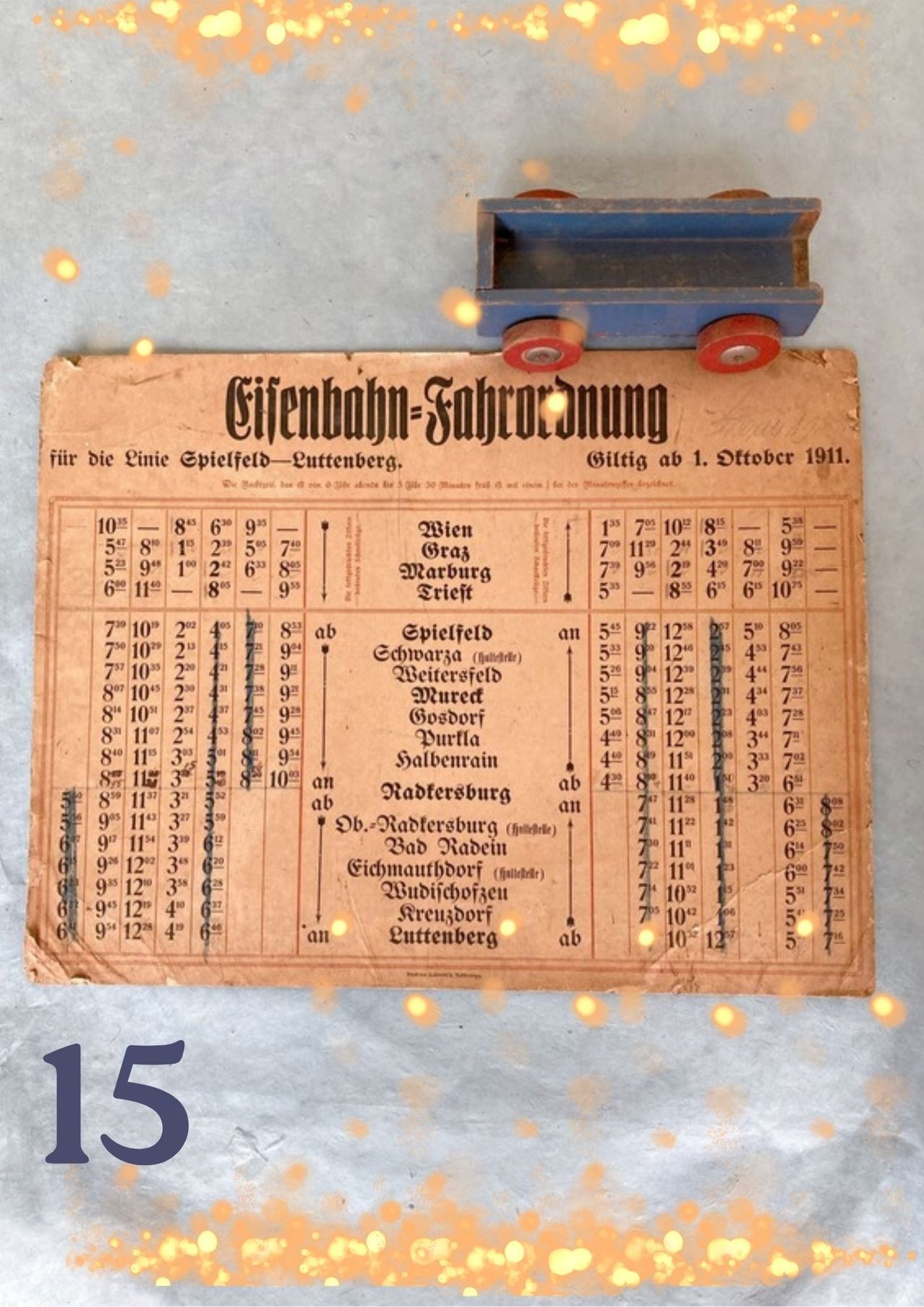 Ein alter Fahrplan für die Stadtbahn-Fahrordnung von 1911 für die Linie zwischen Spielfeld und Luttenberg. Es enthält Haltestellen, Entfernungen und Zeiten. Das Bild ist alt und abgenutzt, mit einem Spielzeugzug obenauf.