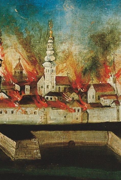 Ein Gemälde zeigt eine brennende Stadt mit einem prominenten weißen Turm in der Mitte. Flammen umschließen die Gebäude, und Rauch steigt von der Szene auf.