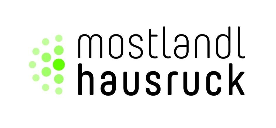 Das Logo für Mostland Hausruck zeigt einen stilisierten grünen Kreis mit Punkten, links neben dem Text 'mostland hausruck' in fetten schwarzen Buchstaben.