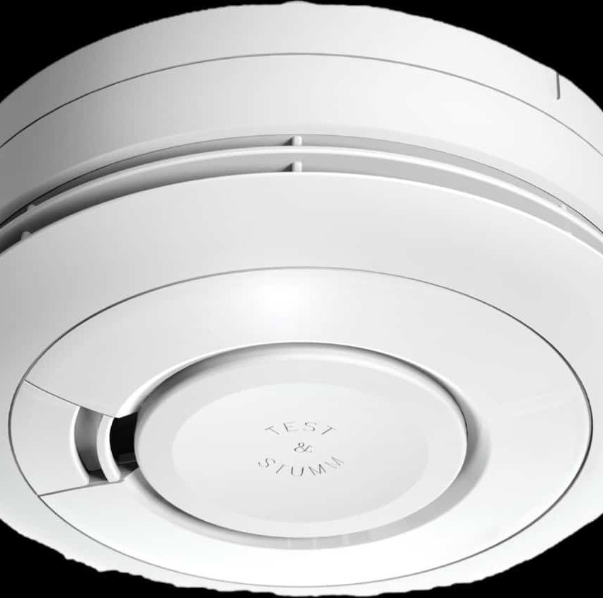 Nahaufnahme eines weißen Rauchmelders mit der Aufschrift 'TEST & STORM' auf der Vorderseite. Das Gerät ist kreisförmig mit einem glatten, schlanken Design.