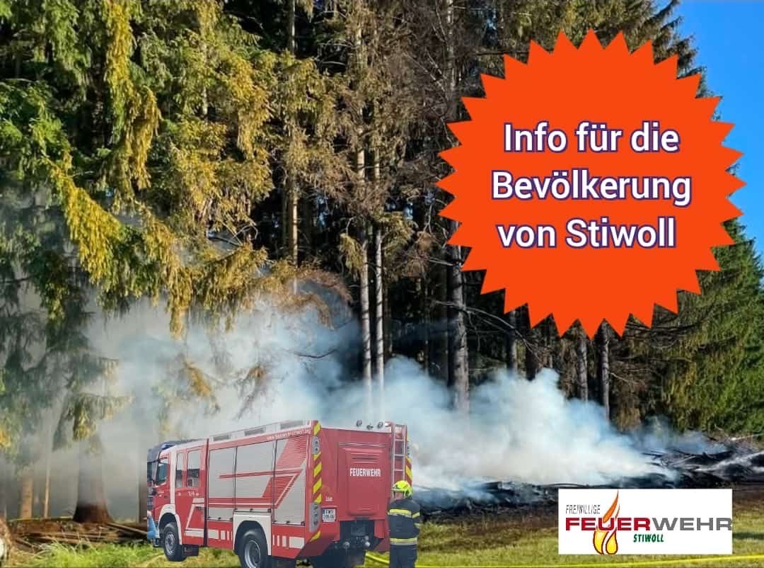 A fire truck is on a grassy field with smoke in the background. The text 'Info fur die Bevolkerung von Stiwol' is displayed in an orange circle. A firefighter is standing beside the truck.