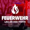 Das Bild zeigt ein Logo für eine Feuerwehr, mit einem Feuerwehrauto im Hintergrund. Das Logo lautet 'FEUERWEHR LAA AN DER THAY', und das Feuerwehrauto ist rot.