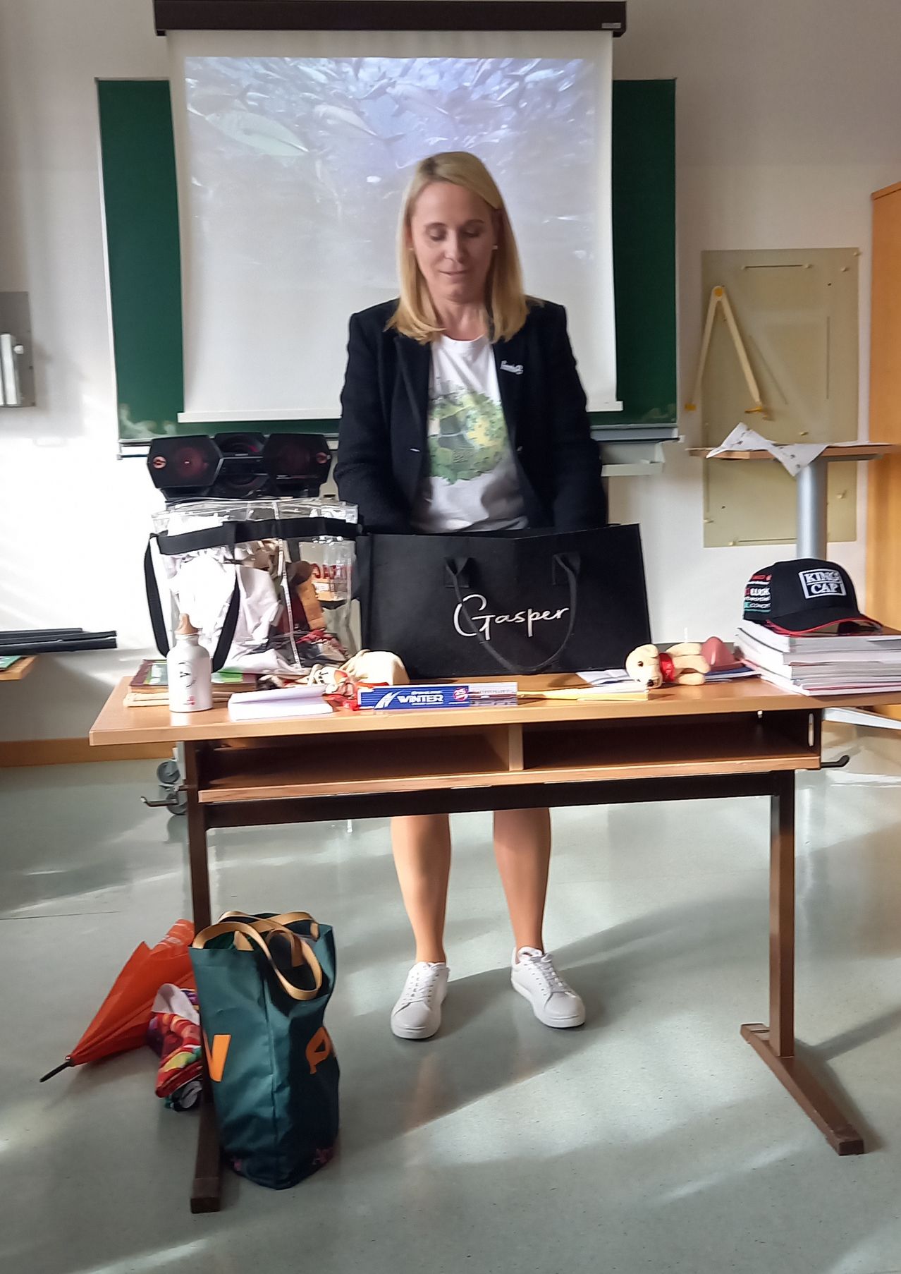 Bild enthält, Furniture, Table, Desk, People, Person, Laptop, Blazer, Suit, Flooring, Handbag