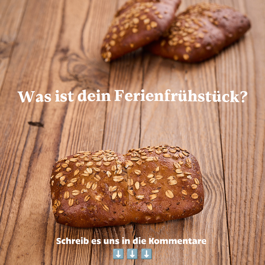 Ein Laib Vollkornbrot mit Sesamkörnern auf einem Holztisch, mit zwei weiteren Stücken im Hintergrund, und einer Textüberlagerung, die nach dem Frühstück der Ferien fragt.