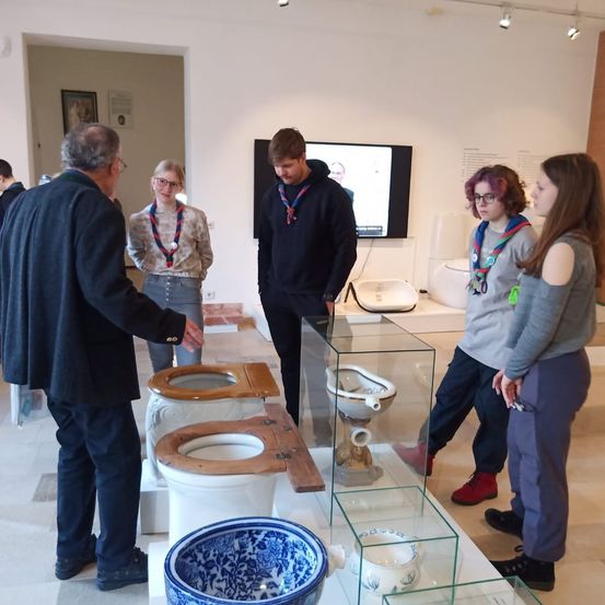 Bild enthält, Indoors, Pants, Table, Museum, Coat, Adult, Male, Man, Person, Blazer