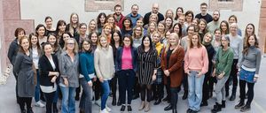 Bild enthält, Groupshot, Person, Jeans, Pants, Building, College, Shoe, Coat, Plant, Face