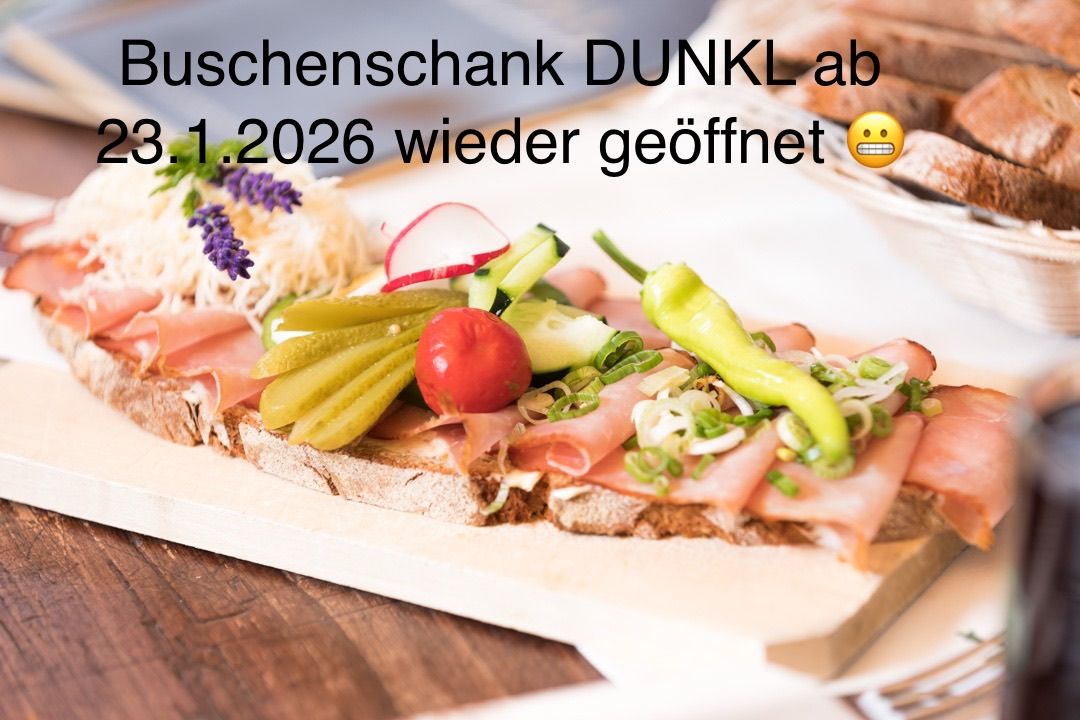 Ein Sandwich auf einem Holztisch mit Schinken, Gurken, Tomaten und Gemüse. Der Textüberlagerung lautet 'uschenschank DUNKL ab 1.2026 wieder geöffnet'. Ein lächelndes Emoji ist vorhanden.
