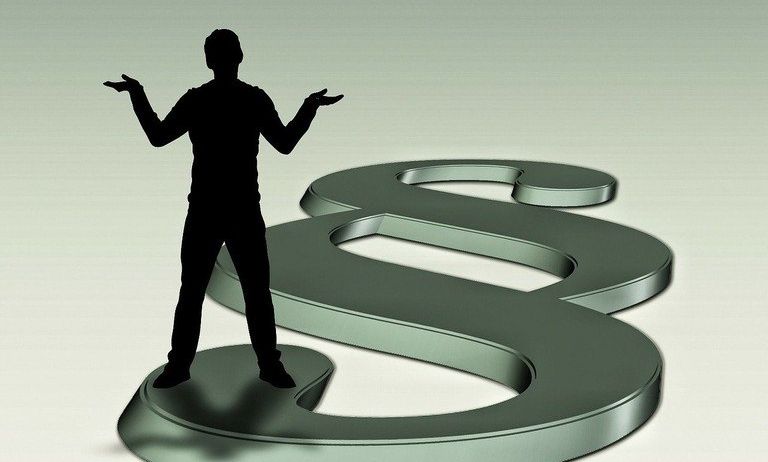 A silhouette of a man with arms outstretched stands atop a large dollar sign symbol. The figure is dark against a light green background.