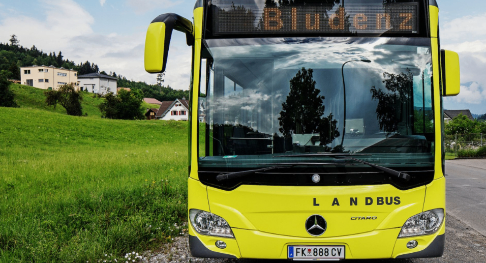 Ein gelber Mercedes-Benz Citaro Bus steht auf einem Schotterweg. Er hat ein digitales Display mit der Aufschrift Bludenz. Der Bus hat ein Kennzeichen FK 888 CV.