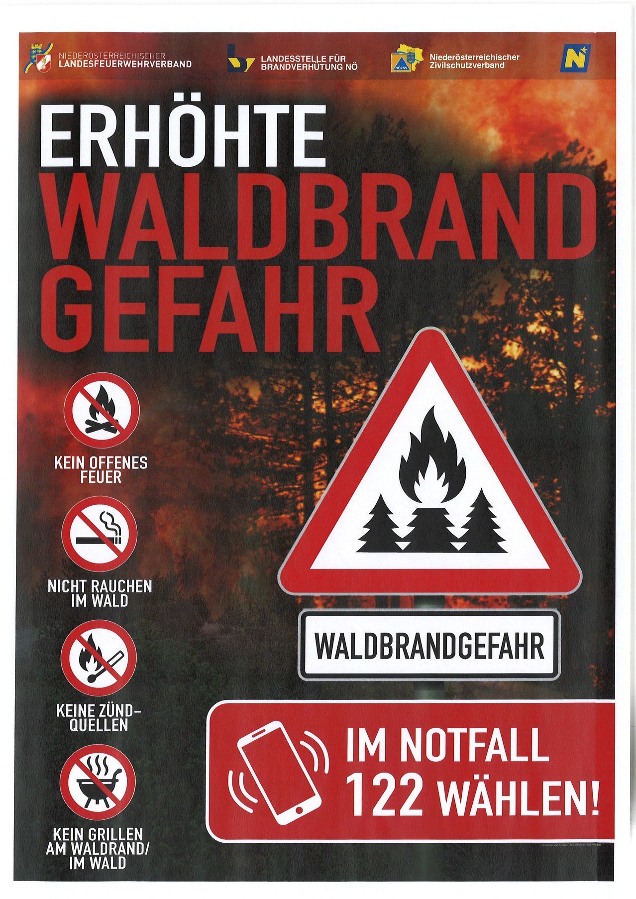 Ein Schild mit rotem Hintergrund warnt vor Waldbrandgefahr. Es zeigt ein Feuersymbol, ein Rauchverbotsschild und ein Schild für offenes Feuer. Es gibt auch ein Warnzeichen für Waldbrandgefahr.